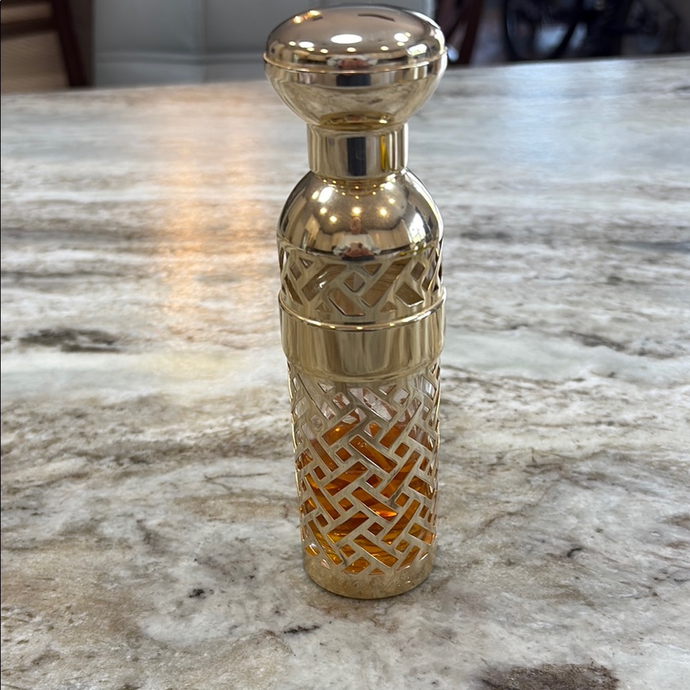 Guerlain perfume housed in a refillable gold lattice canister